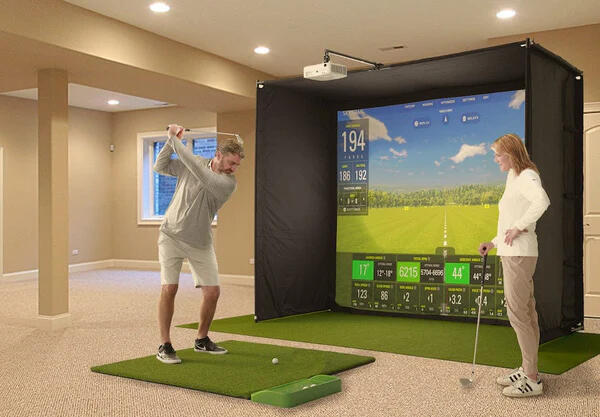 man and woman using a golf simulator indoors